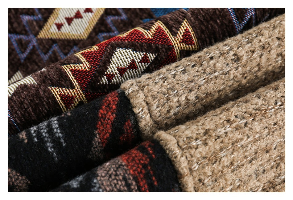Close-up of tan textured fabric alongside dark plaid and brown geometric patterned sections.