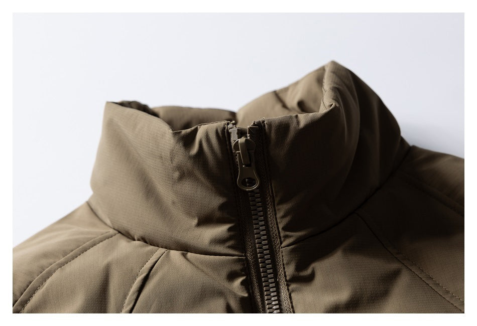 Close-up of an olive-brown padded jacket’s high stand collar and central zipper.