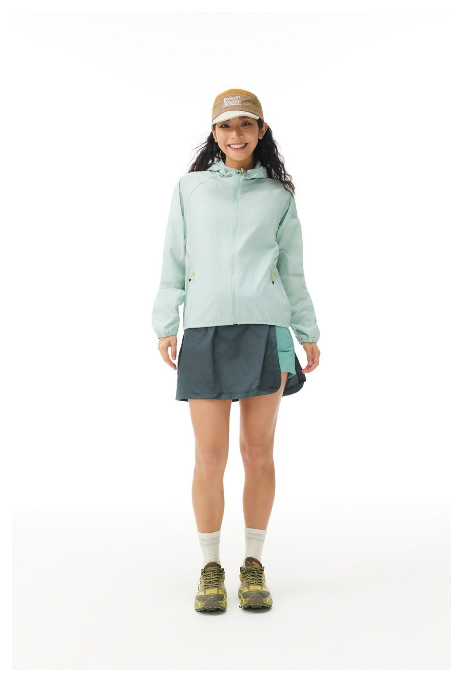 Front view of a model wearing a pale mint hooded jacket and a dark teal skirt with a turquoise panel.