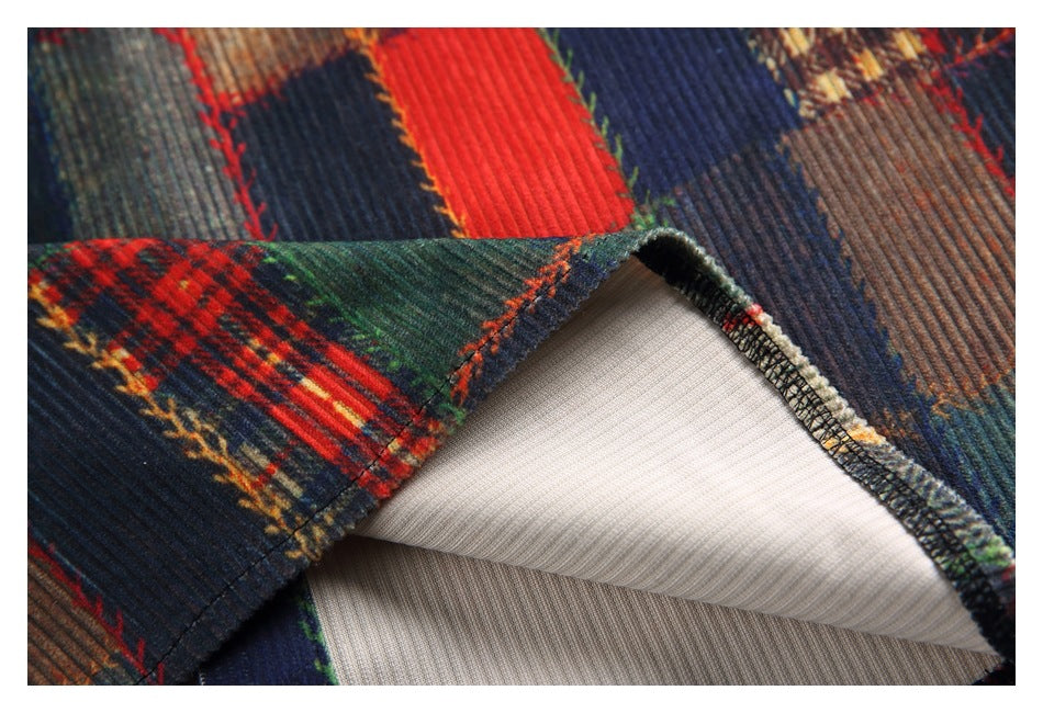 Close-up of a turned garment edge showing the patchwork outer fabric, stitched seam, and pale inner layer.