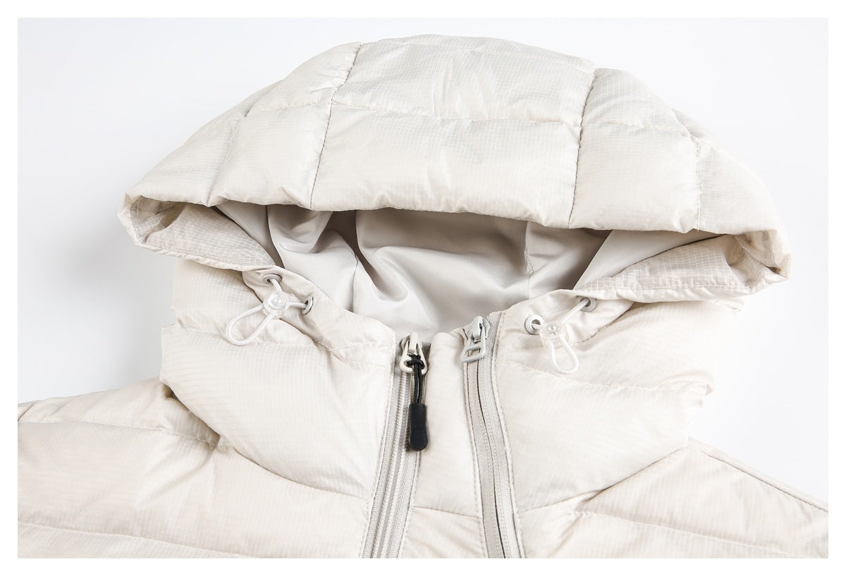 Close-up of an off-white padded jacket hood with drawcords and front zipper.