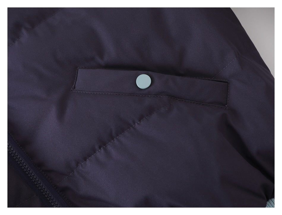 Close-up of a dark navy jacket pocket flap with a light blue snap button and visible zipper edge.