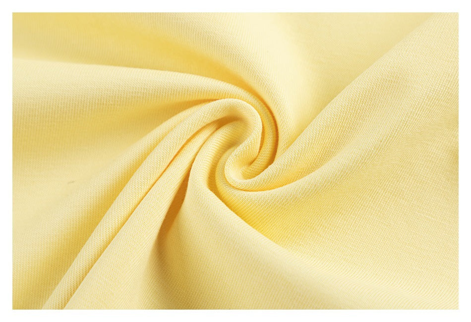 Close-up of pale yellow T-shirt fabric gathered into folds.