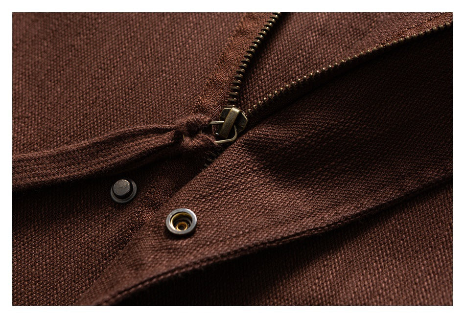 Close-up of a brown jacket's zipper and metal snap fasteners.