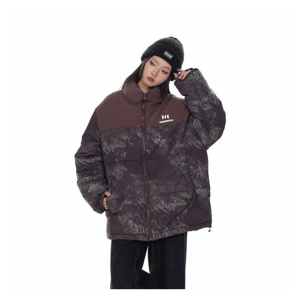 Model wearing a charcoal marbled puffer jacket with a burgundy yoke and collar, paired with a black knit beanie.