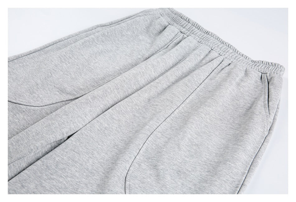 Close-up of light-gray shorts showing the elastic waistband and curved front pocket seams.