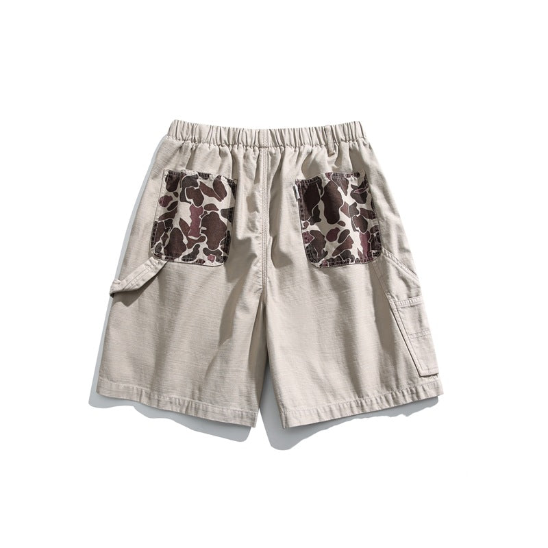 Rear view of light beige shorts with an elastic waistband, camouflage-print patch pockets, and side cargo pockets.