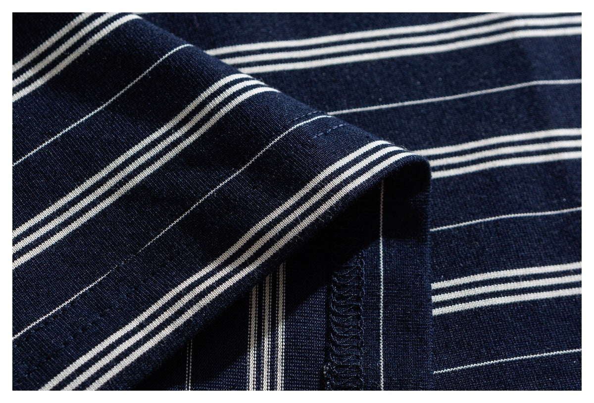 Close-up of navy-and-white striped fabric showing a folded edge and overlocked seam.
