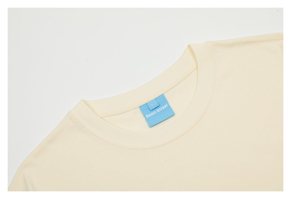 Close-up of a cream T-shirt crew neck and blue Beast Street size label.