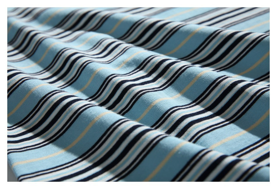 Close-up of light blue knit fabric with repeating black, white, and thin tan stripes arranged in soft folds.