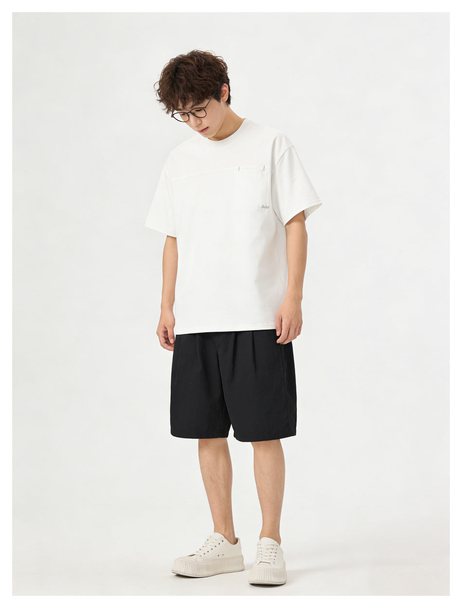 Model wearing a white short-sleeve T-shirt with a horizontal chest seam and black shorts, front view.