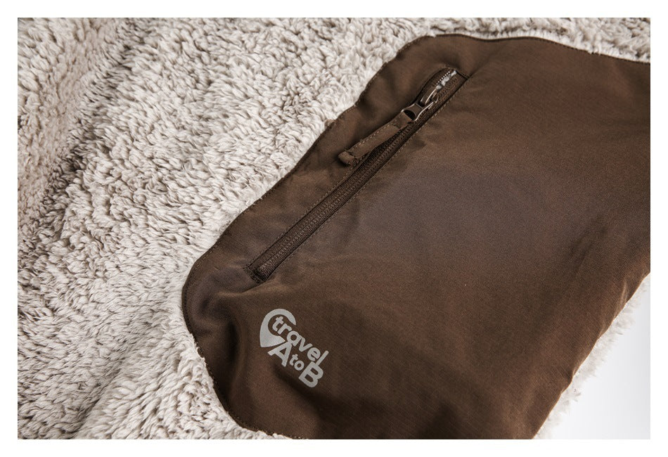 Close-up of a brown garment with a diagonal zipper and a small light-colored logo on the fabric.