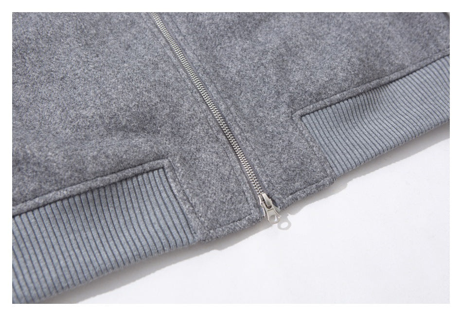 Close-up of the gray jacket's front zipper and ribbed hem band.