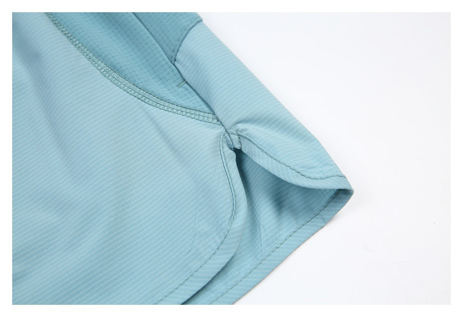 Close-up of blue-green garment stitching and a curved hem.