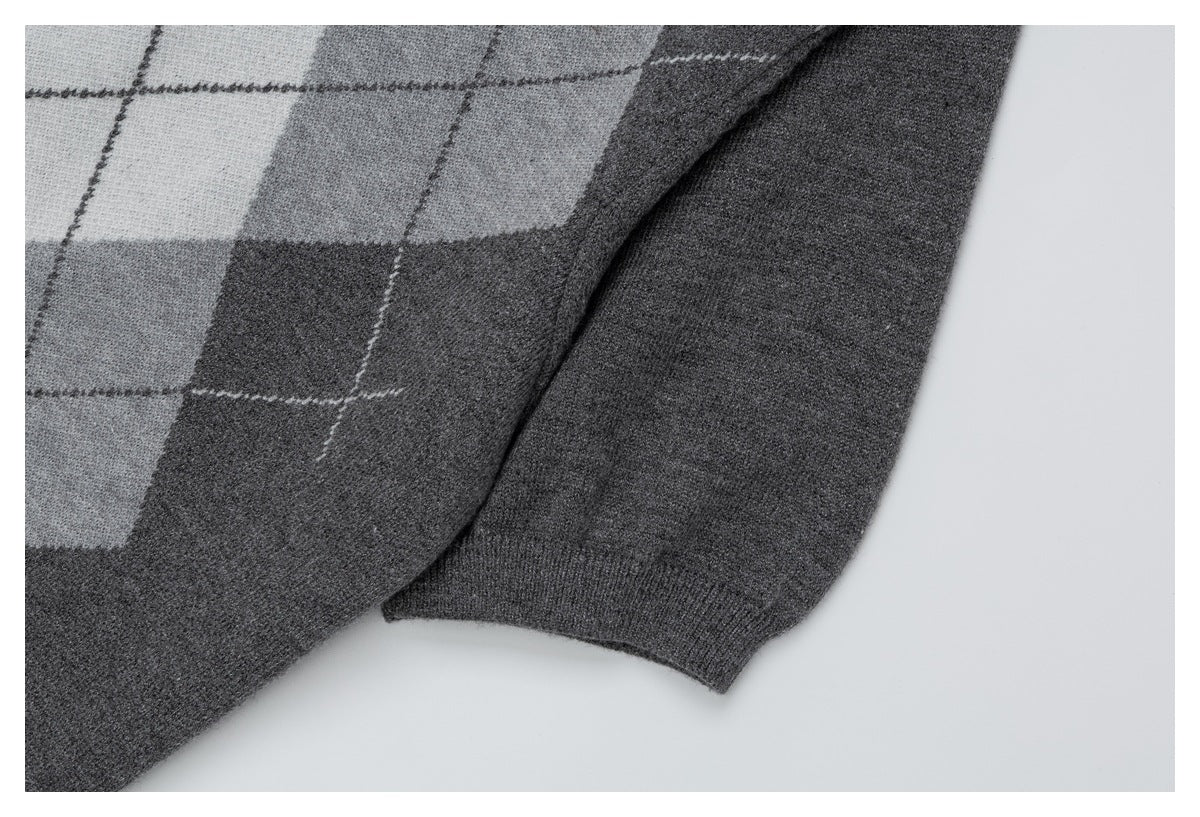 Close-up of a gray argyle cardigan sleeve and ribbed cuff against a plain background.