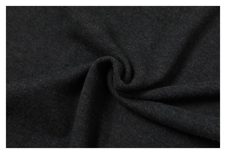 Close-up of charcoal knit fabric gathered into a small central swirl.
