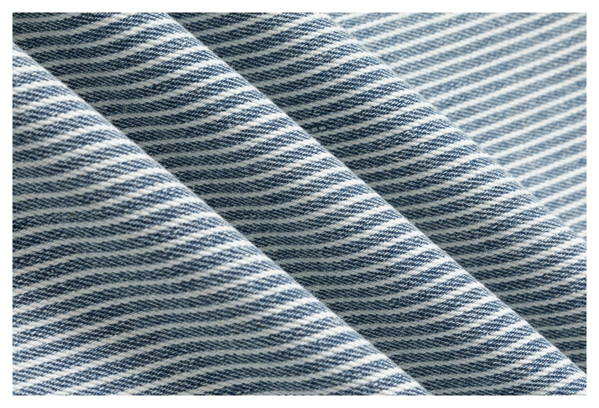 Close-up of folded blue-and-white striped fabric showing its woven texture.