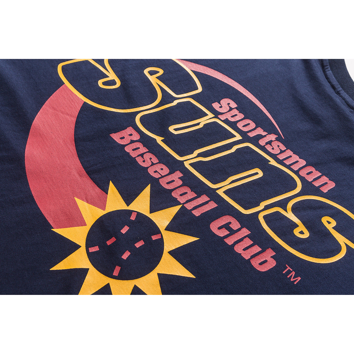 Close-up of a colorful yellow and red sports graphic printed on navy fabric, with English lettering.