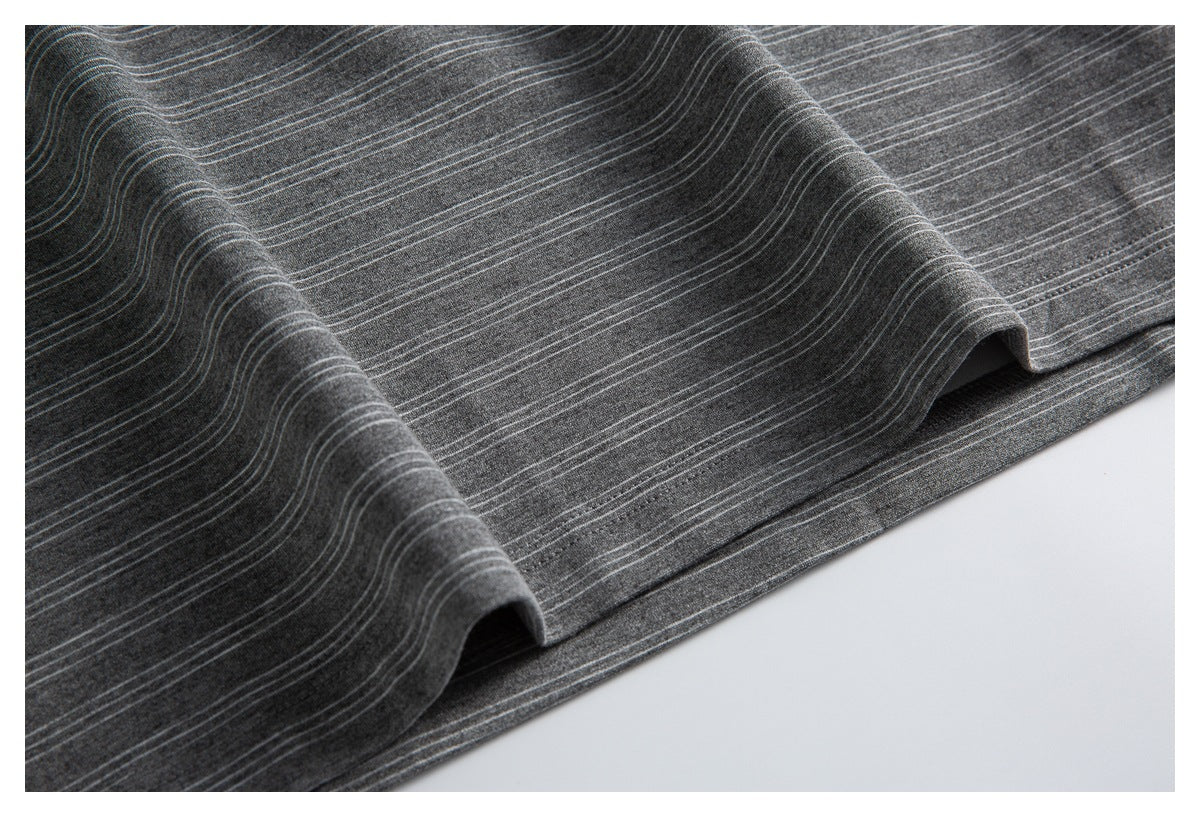 Close-up of the striped charcoal gray shirt fabric draped to show its stitched hem.