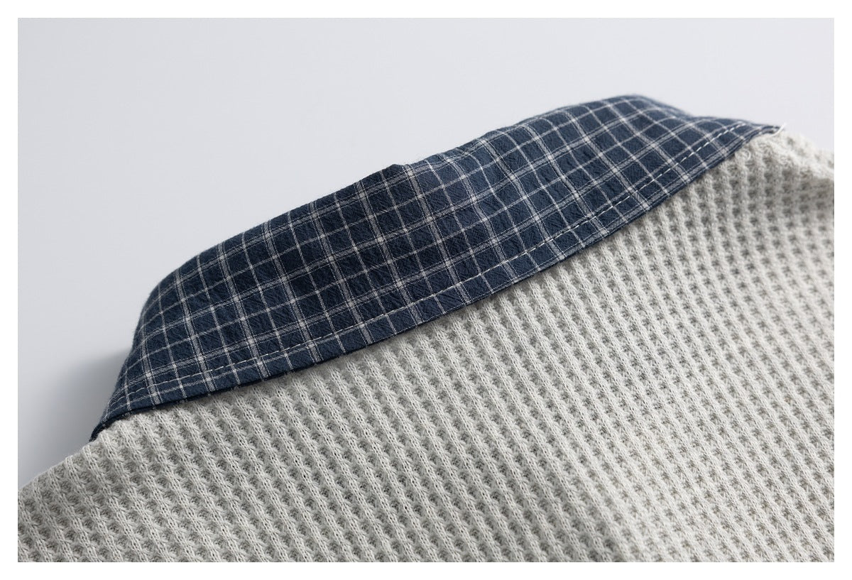 Close-up of a navy plaid panel joined to light gray ribbed knit fabric.