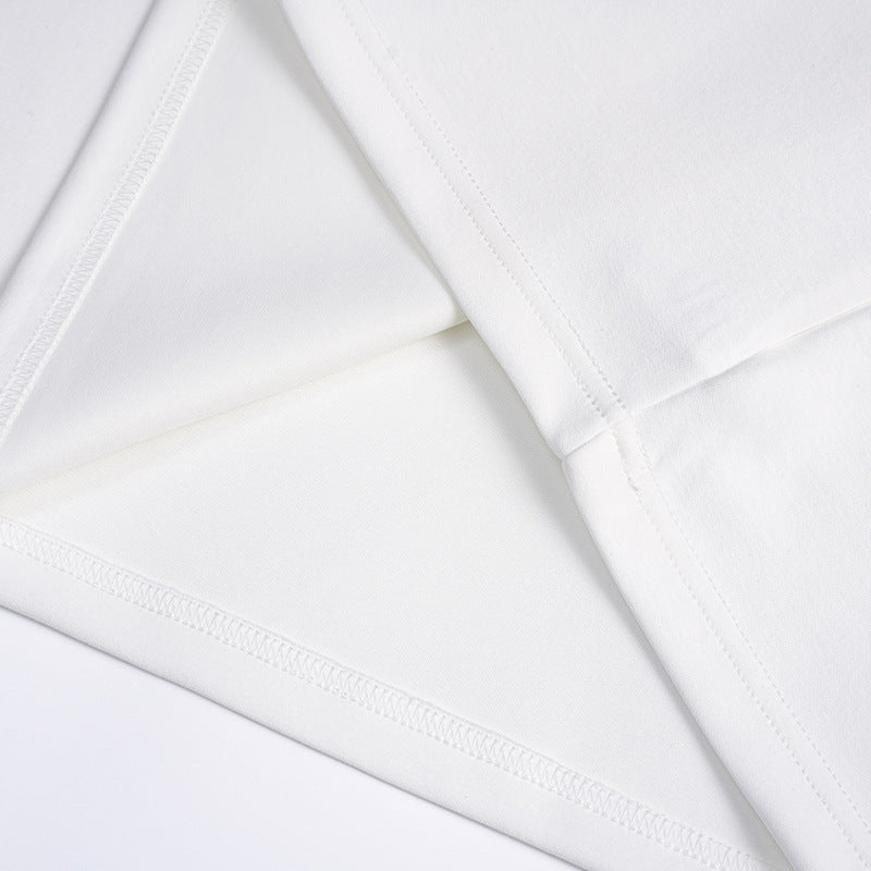 Close-up of the white T-shirt's fabric, hem, and overlocked seam stitching.