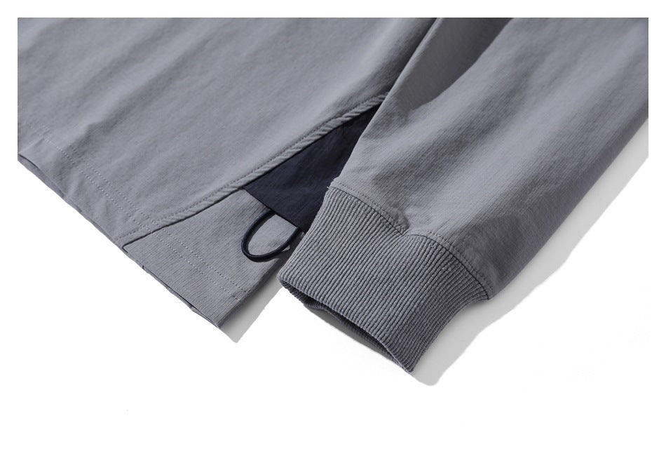 Gray top shown at the side hem and ribbed sleeve cuff, with a dark insert and loop detail.