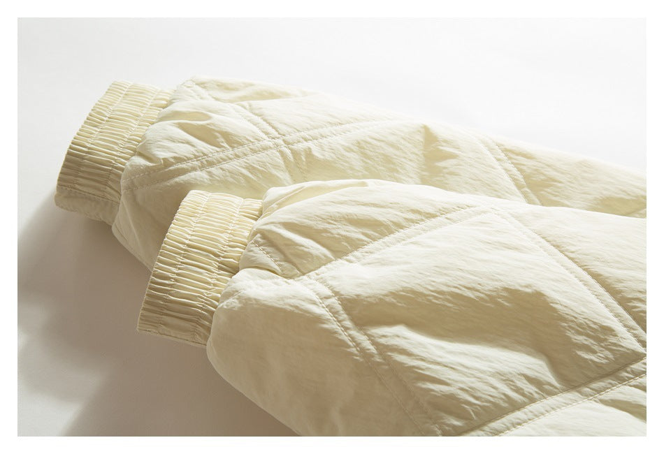 Close-up of the ivory quilted jacket's sleeves and wide gathered elastic cuffs.