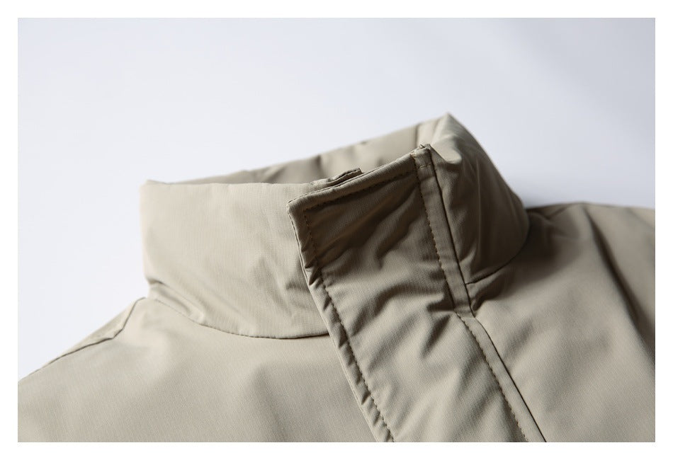 Close-up of a taupe jacket's stand collar and covered front fastening.