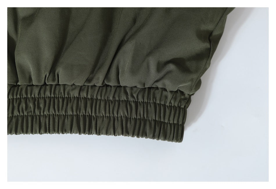 Close-up of an olive jacket's gathered elastic hem.