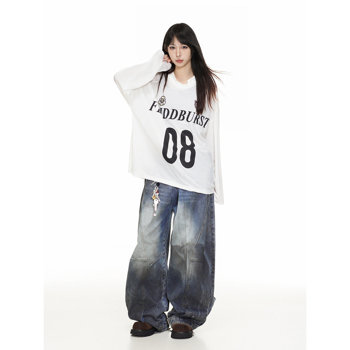 Full-length model wearing an oversized white long-sleeve jersey with black lettering and number 08, paired with baggy jeans.