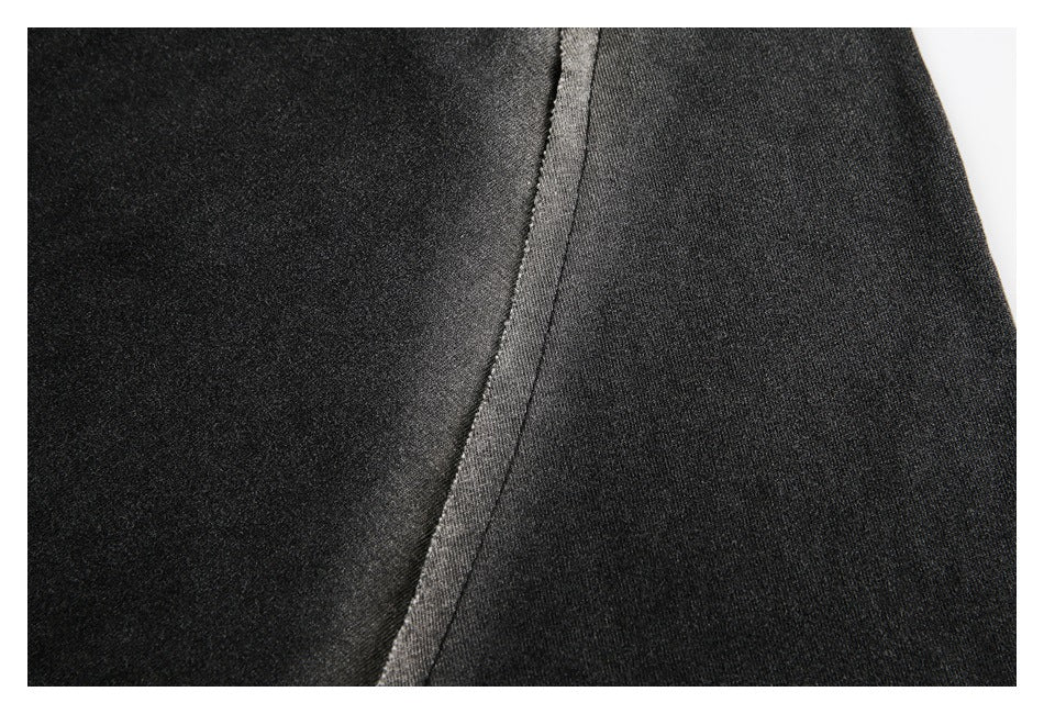 Close-up of a dark shirt showing a curved seam and contrasting fabric panels.