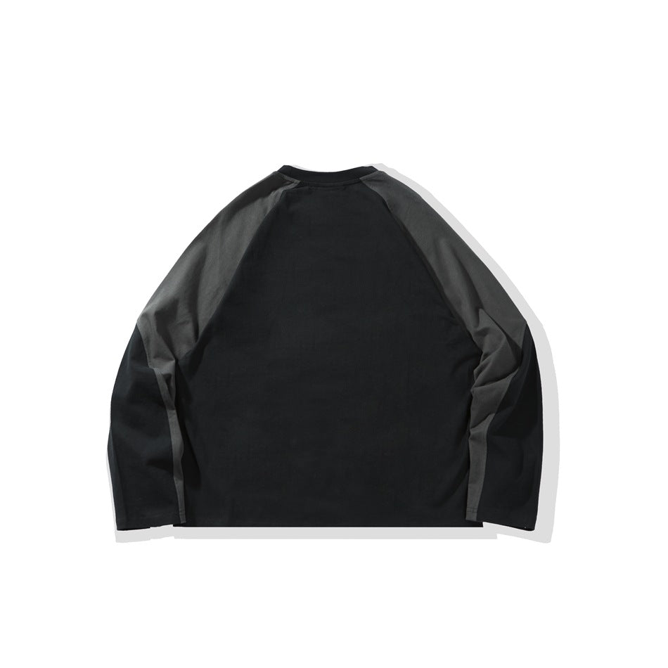 Back view of a black long-sleeve raglan shirt with charcoal gray shoulder and sleeve panels, laid flat.