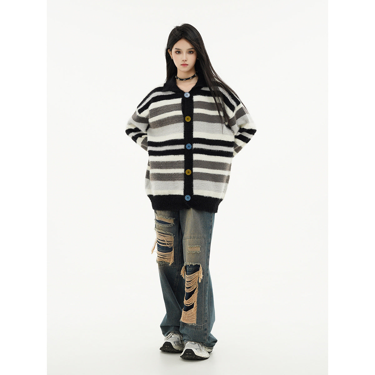 Model wearing an oversized black, gray, and cream striped button-front cardigan with distressed wide-leg jeans.