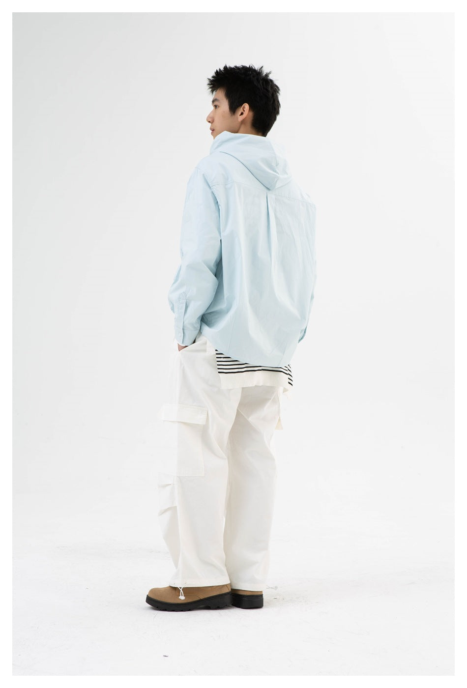 Model wearing light blue hooded shirt with white cargo pants, back view showing hood and back yoke pleat
