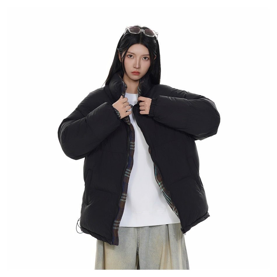Model wearing an open black puffer jacket with plaid lining visible along the front.