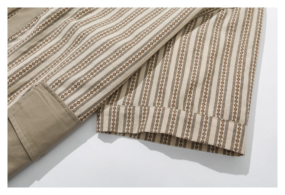 Close-up of a beige and brown striped garment with geometric motifs and a solid taupe cuff or hem panel.