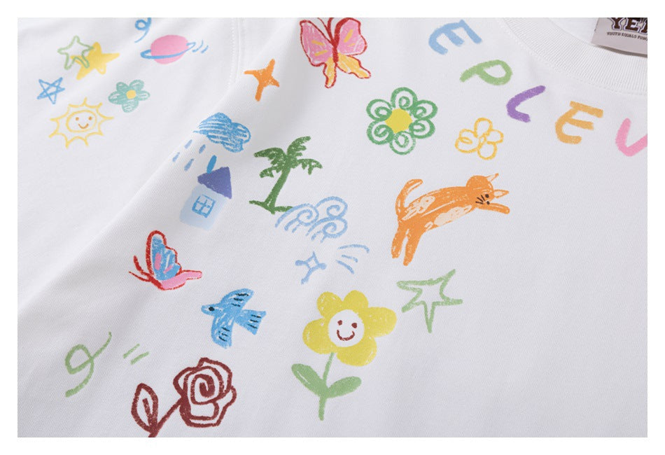 Close-up of colorful hand-drawn flowers, animals and lettering printed on a white T-shirt.