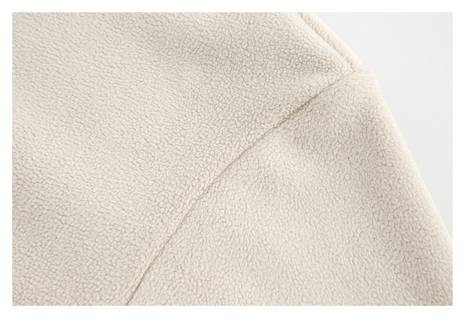 Close-up of the cream garment's textured shoulder and curved seam.