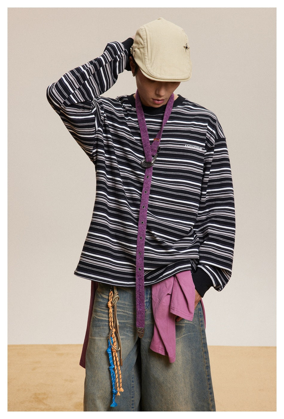 Closer view of a model wearing a black long-sleeve shirt with white and gray horizontal stripes.