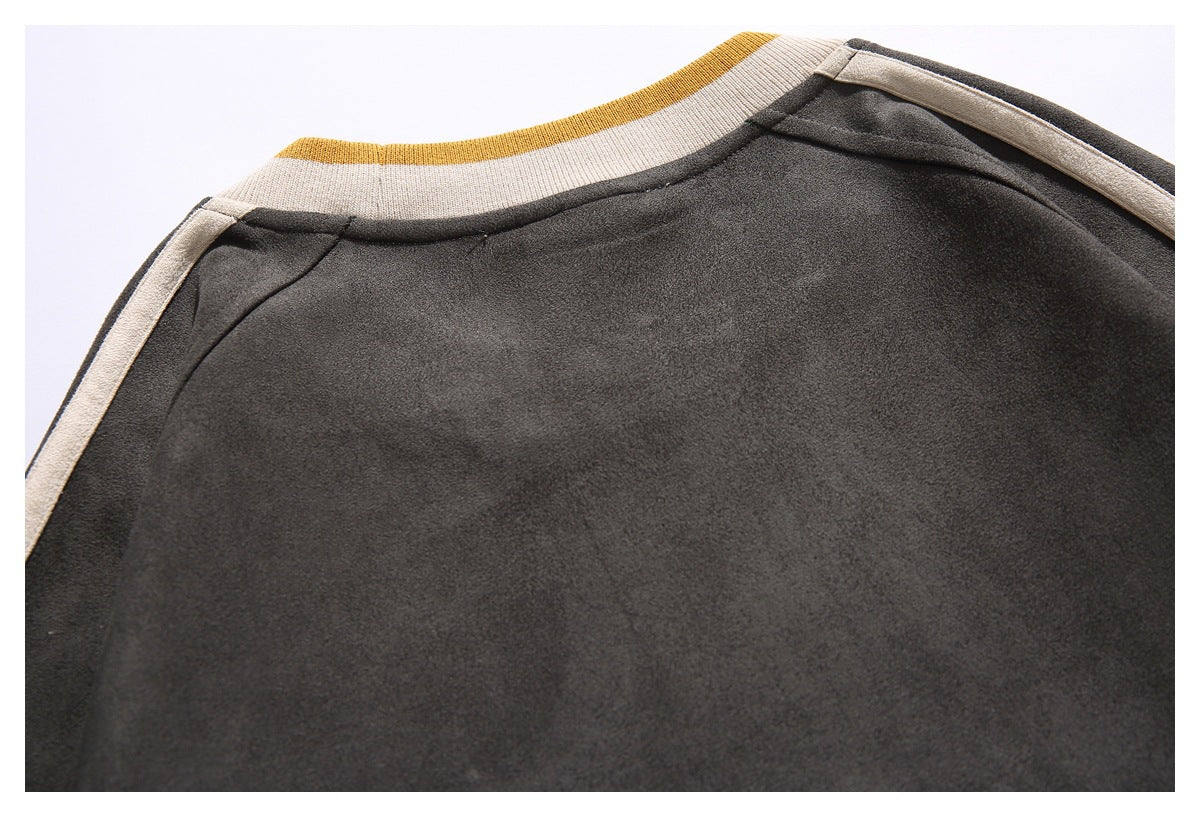 Close-up of a charcoal garment's shoulder and cream ribbed neckline with a mustard stripe.