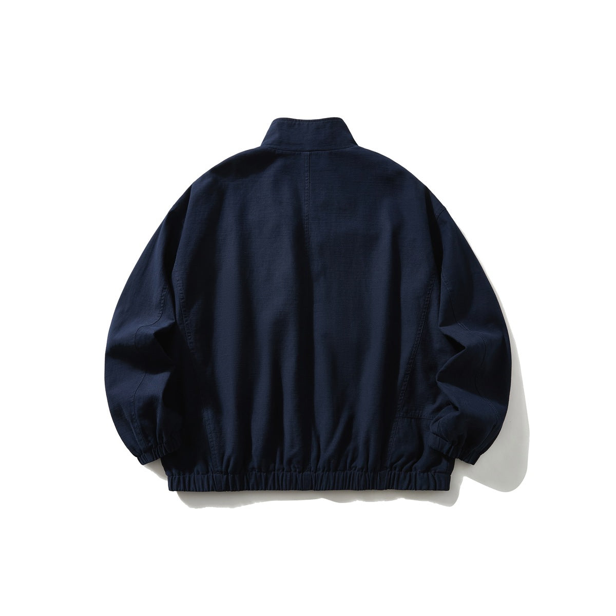 Navy stand-collar jacket back view with center back seam, dropped shoulders and elastic cuffs and hem, flat lay
