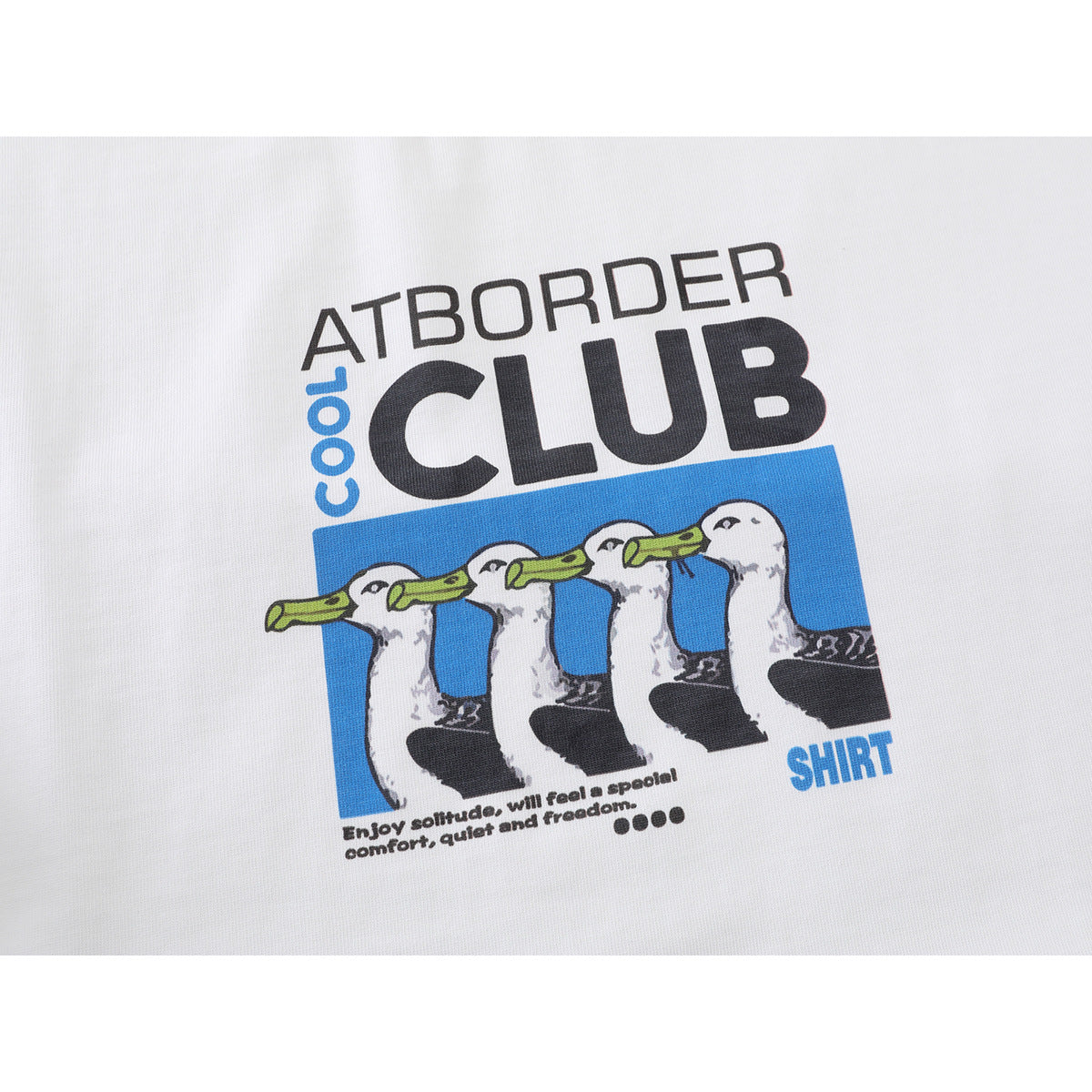 Close-up of a white shirt’s chest print with four illustrated ducks and English lettering.