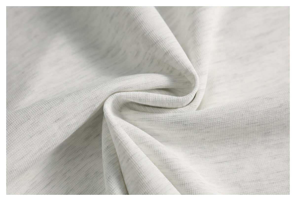 Close-up of light gray fabric gathered into folds, showing its fine texture.
