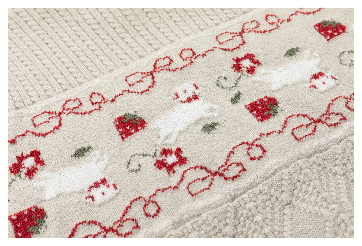 Close-up of the cream sweater's patterned band with red bows, strawberries, small animal motifs, and green accents.