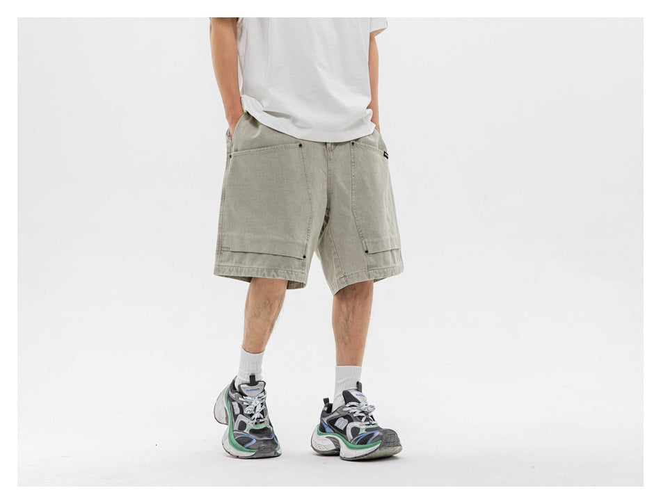 Front view of a model wearing loose light gray-green shorts with large patch pockets.