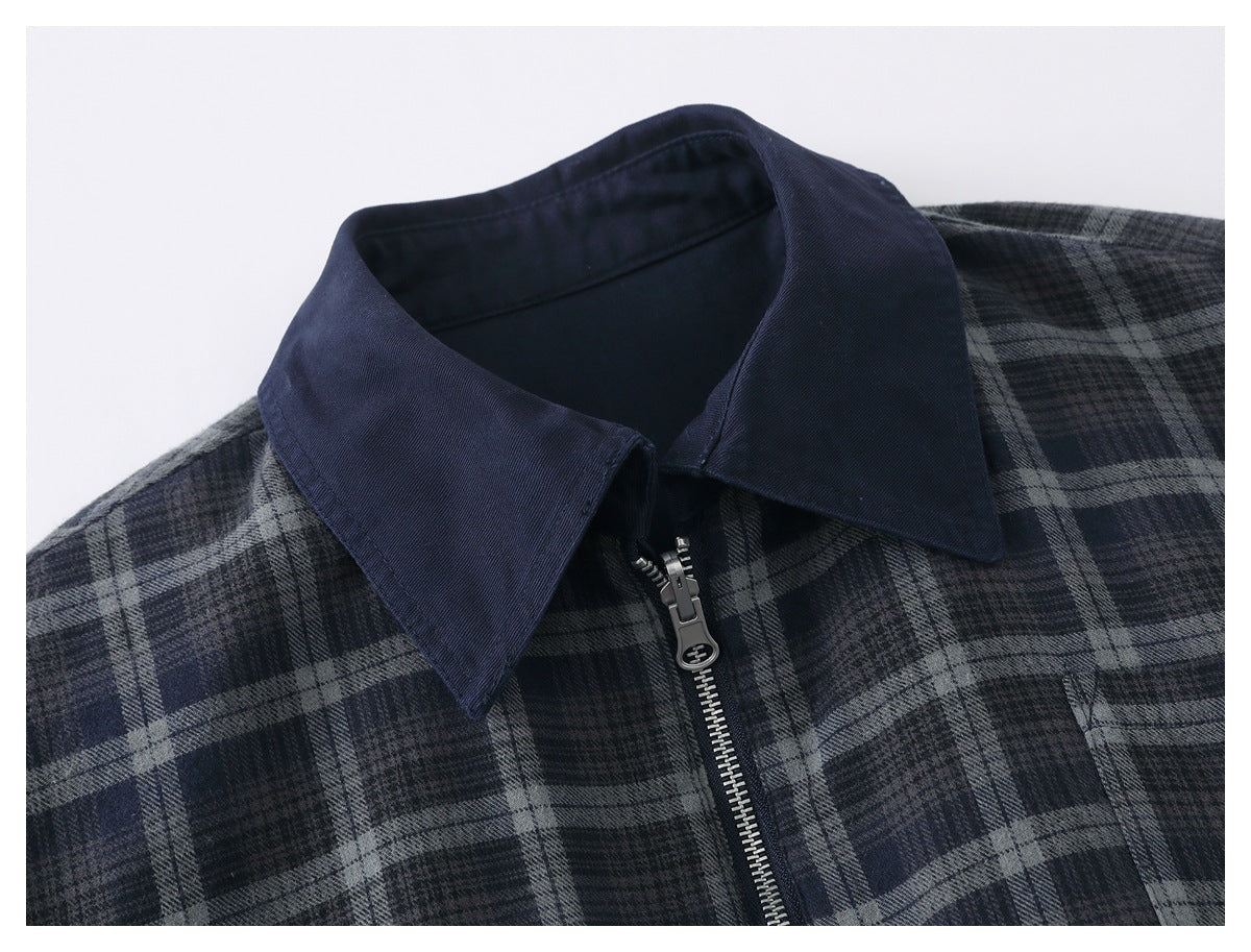 Close-up of the jacket's navy collar, silver zipper, and dark blue and gray plaid fabric.