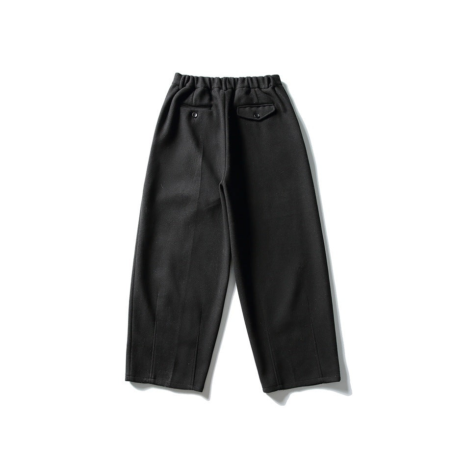 Black wide-leg trousers flat lay, back view, with elastic waistband and two back pockets with button closures
