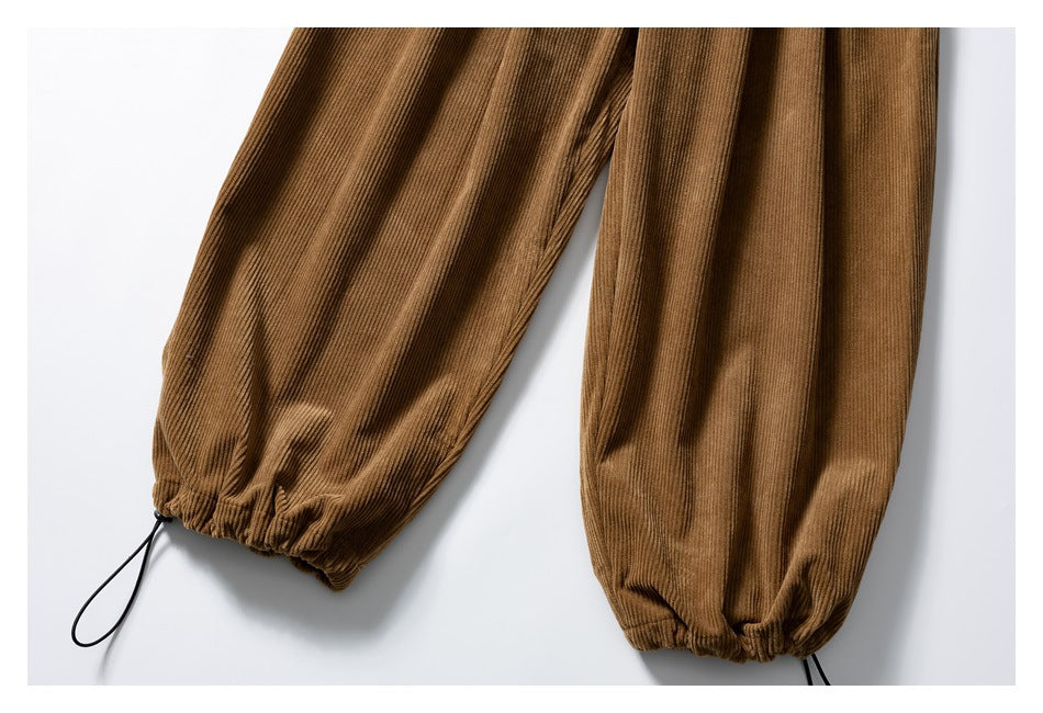 Close-up of the trousers' gathered corduroy cuffs with black adjustable drawcords.