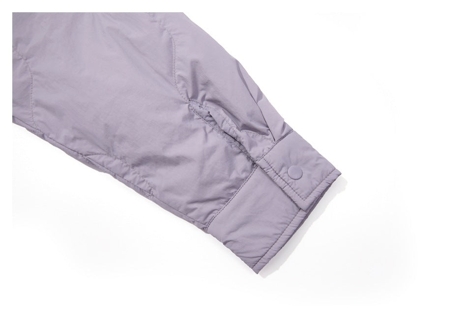 Pale lavender sleeve close-up showing a stitched cuff with a matching snap button.