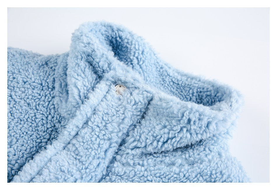 Close-up of a pale blue plush garment collar with a small white button.